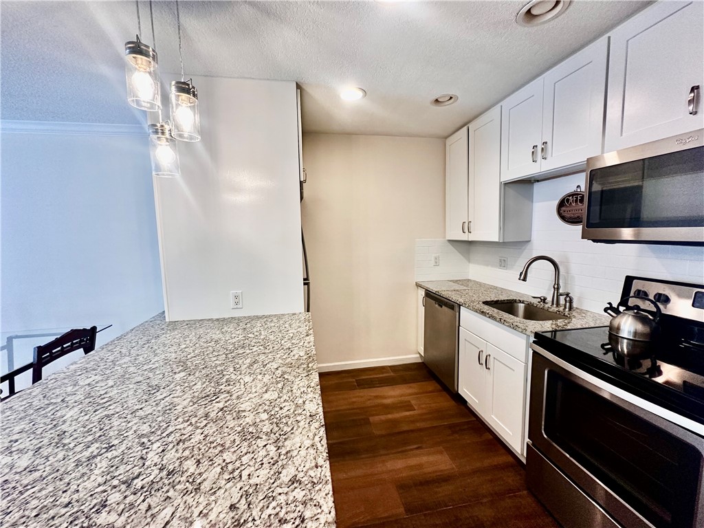 1815 Robalo Drive, Unit C201 Vero Beach, FL 32960 - Photo 6 of 31 a kitchen with granite countertop a sink stainless steel appliances and cabinets