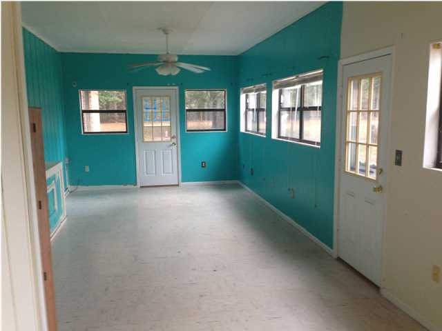 1086 Tallokas Road Crestview, FL 32536 - Photo 17 of 34 a view of an empty room with a window and a kitchen
