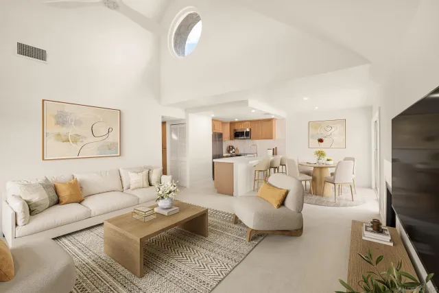 a living room with furniture kitchen view and a flat screen tv