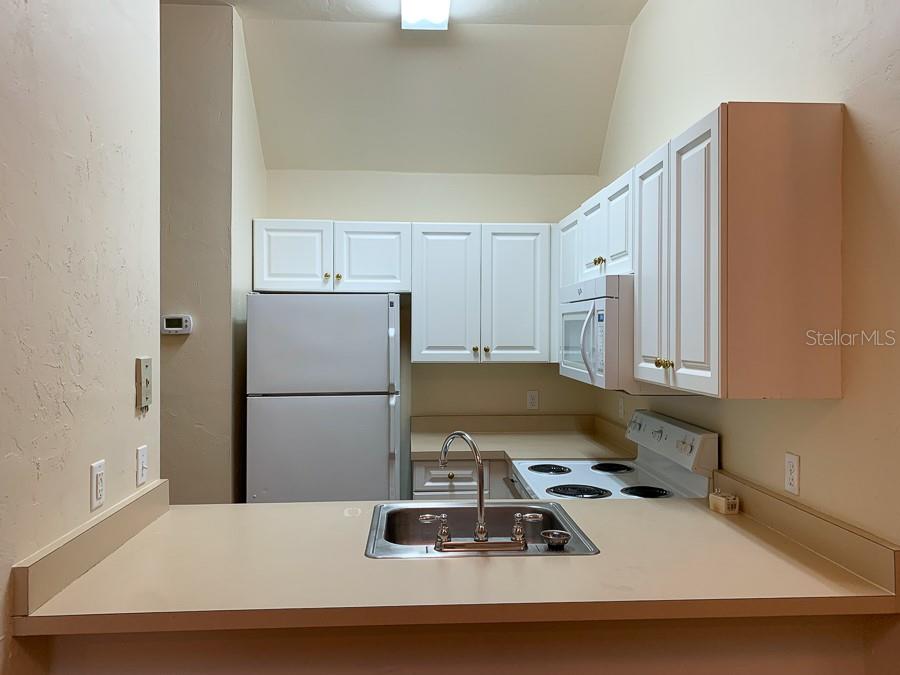 3901 Southwest 27th Street, Unit 5 Gainesville, FL 32608 - Photo 4 of 15 a room with a refrigerator and a stove