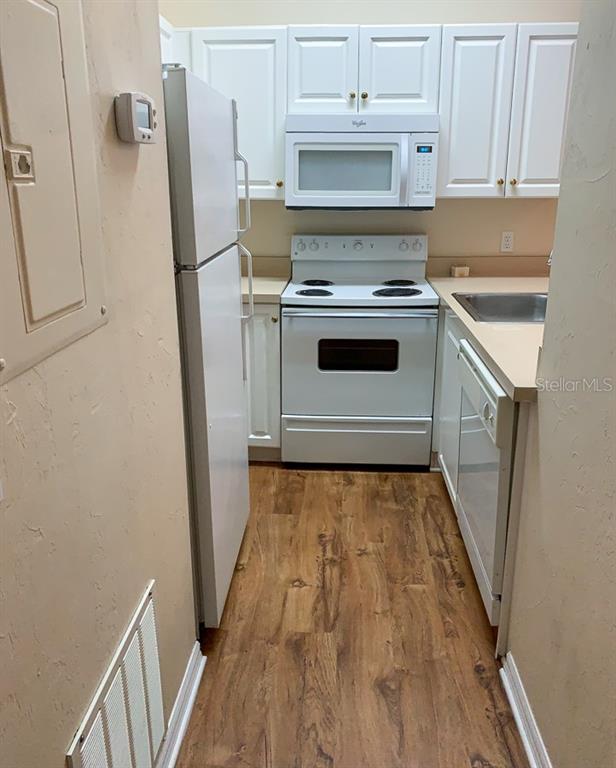 3901 Southwest 27th Street, Unit 5 Gainesville, FL 32608 - Photo 5 of 15 a kitchen with white cabinets and white appliances