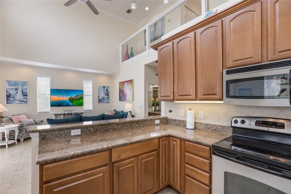316 64th Street Holmes Beach, FL 34217 - Photo 17 of 43 a kitchen with stainless steel appliances granite countertop a sink stove and cabinets