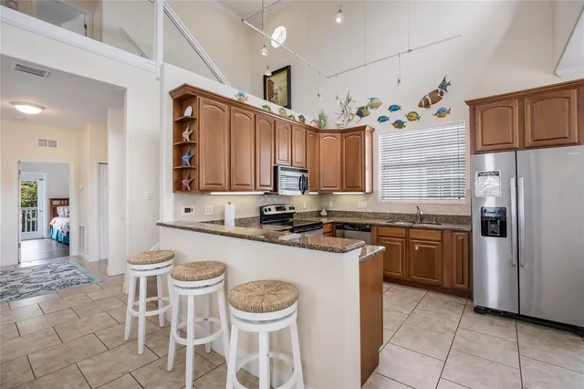 a kitchen with stainless steel appliances granite countertop a sink and a refrigerator