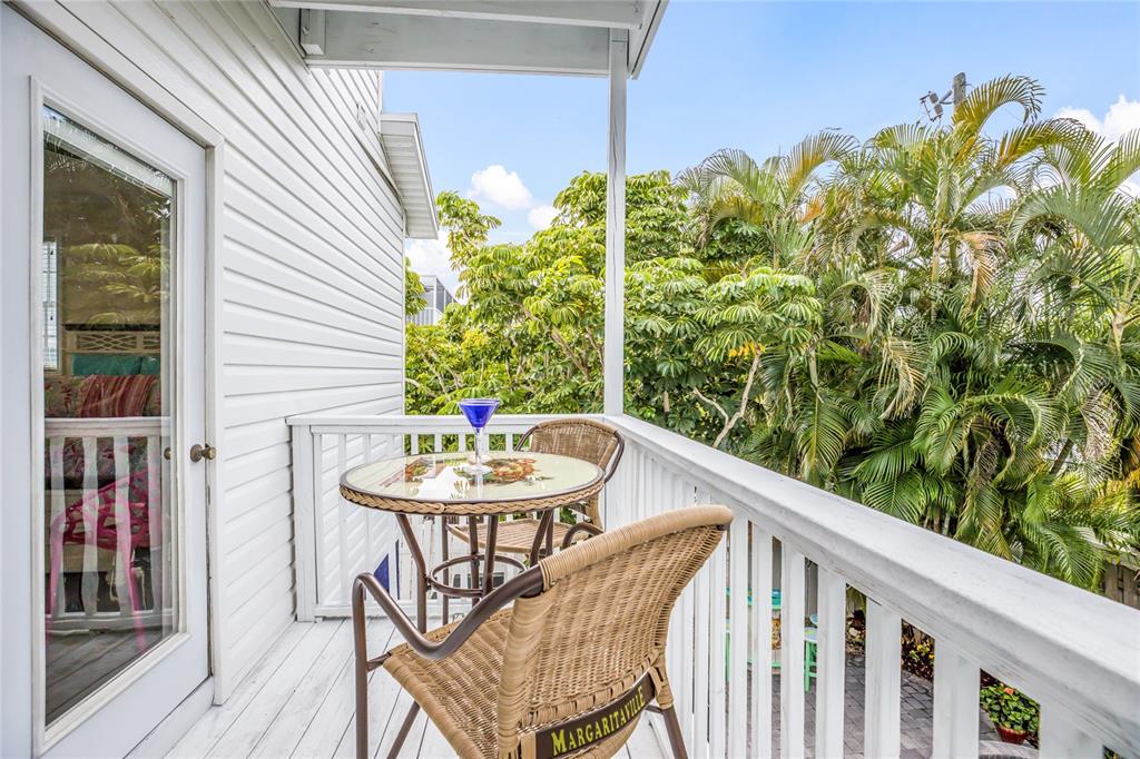 316 64th Street Holmes Beach, FL 34217 - Photo 28 of 43 a balcony with table and chairs and wooden floor