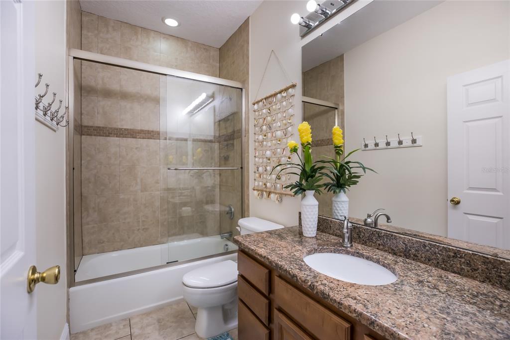 316 64th Street Holmes Beach, FL 34217 - Photo 29 of 43 a bathroom with a granite countertop sink toilet and shower