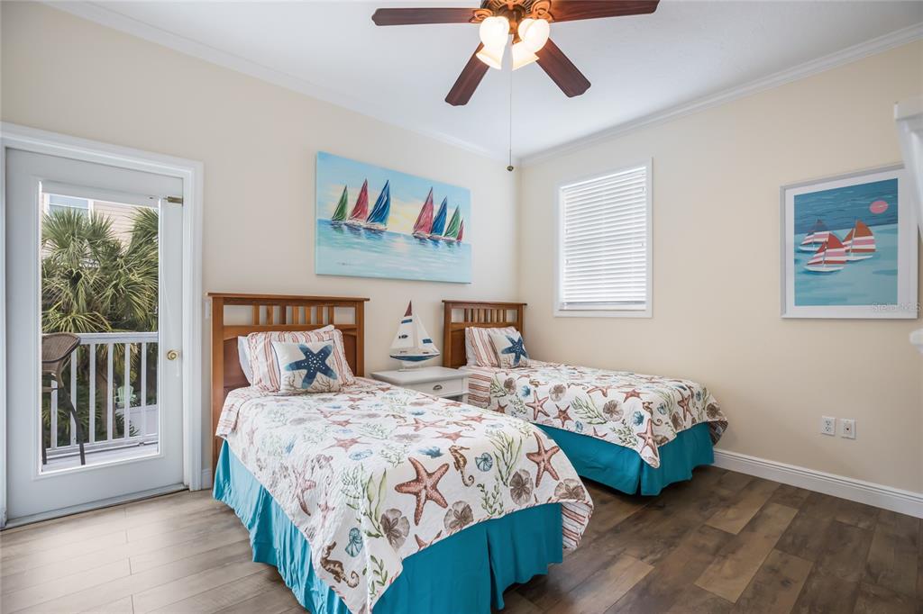 316 64th Street Holmes Beach, FL 34217 - Photo 32 of 43 a bedroom with two beds and a chandelier