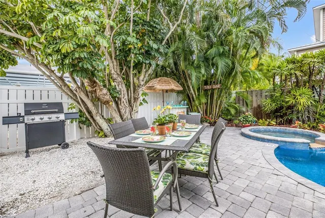 a backyard of a house with barbeque oven table and chairs