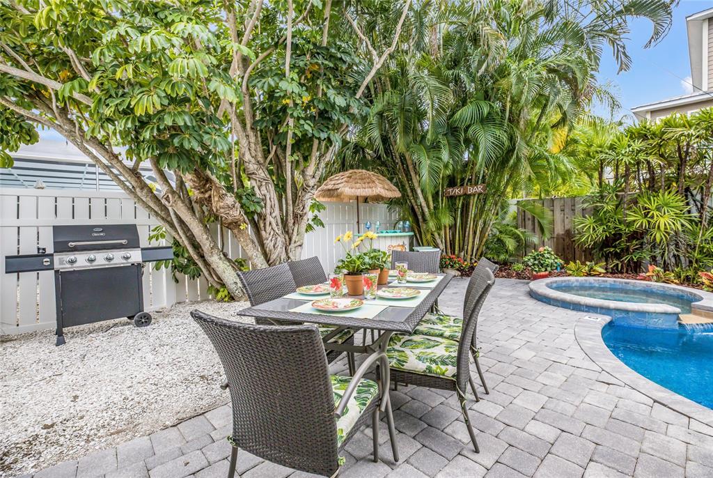 316 64th Street Holmes Beach, FL 34217 - Photo 37 of 43 a backyard of a house with barbeque oven table and chairs