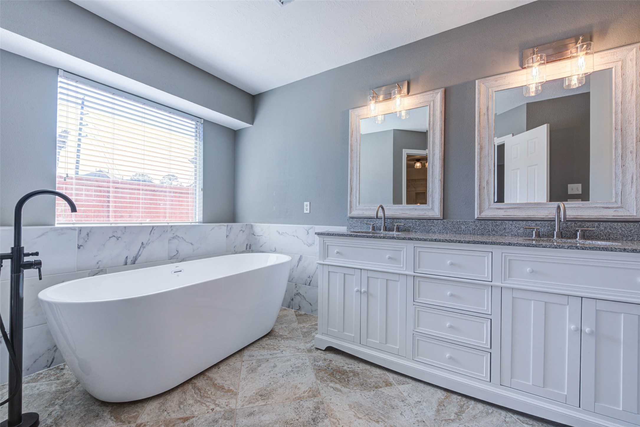 17930 Seven Pines Drive Spring, TX 77379 - Photo 17 of 26 a bathroom with a bathtub a double vanity sink and mirror