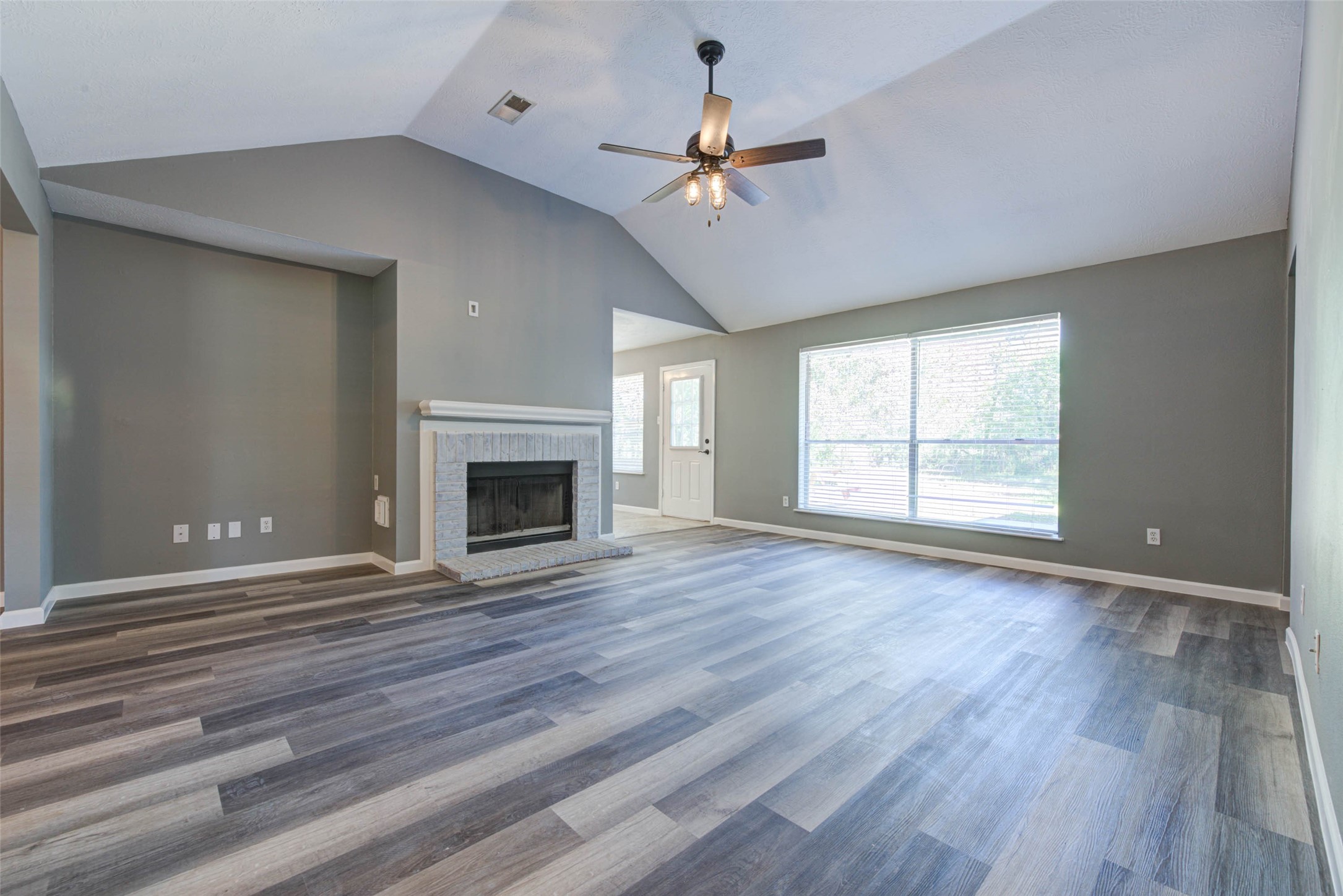 17930 Seven Pines Drive Spring, TX 77379 - Photo 7 of 26 a view of an empty room with wooden floor fireplace and a window