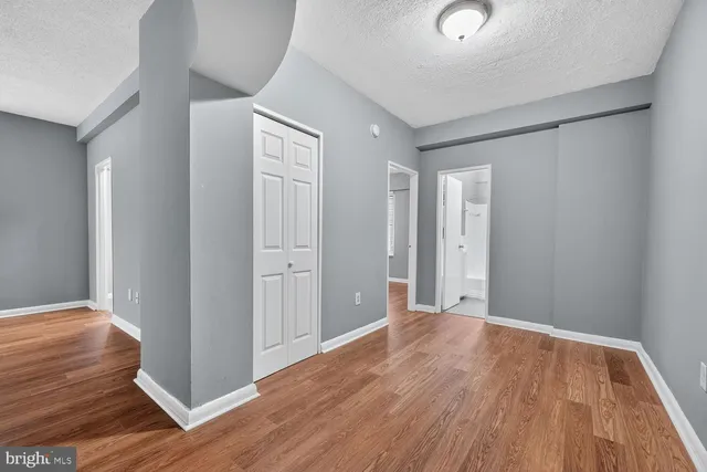 a view of an empty room with wooden floor