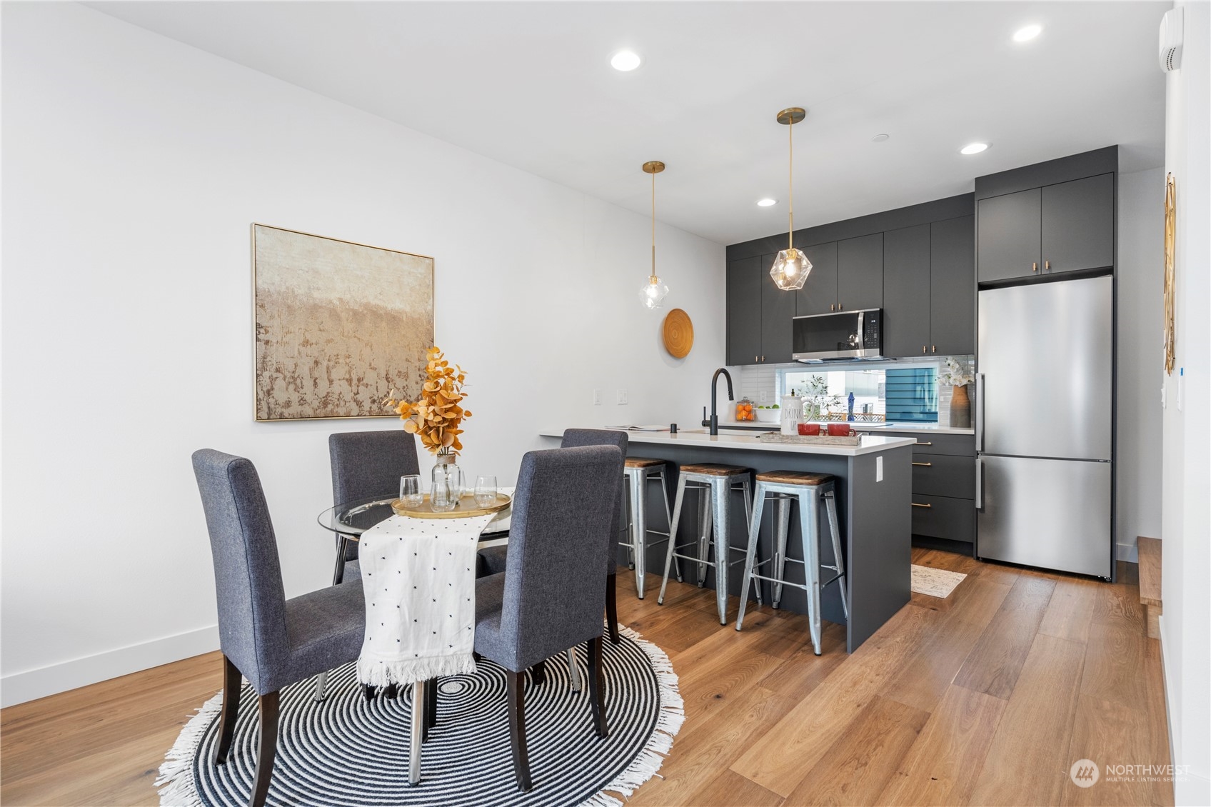 6014 B California Avenue Southwest Seattle, WA 98136 - Photo 12 of 27 a kitchen with kitchen island a stove a table and chairs