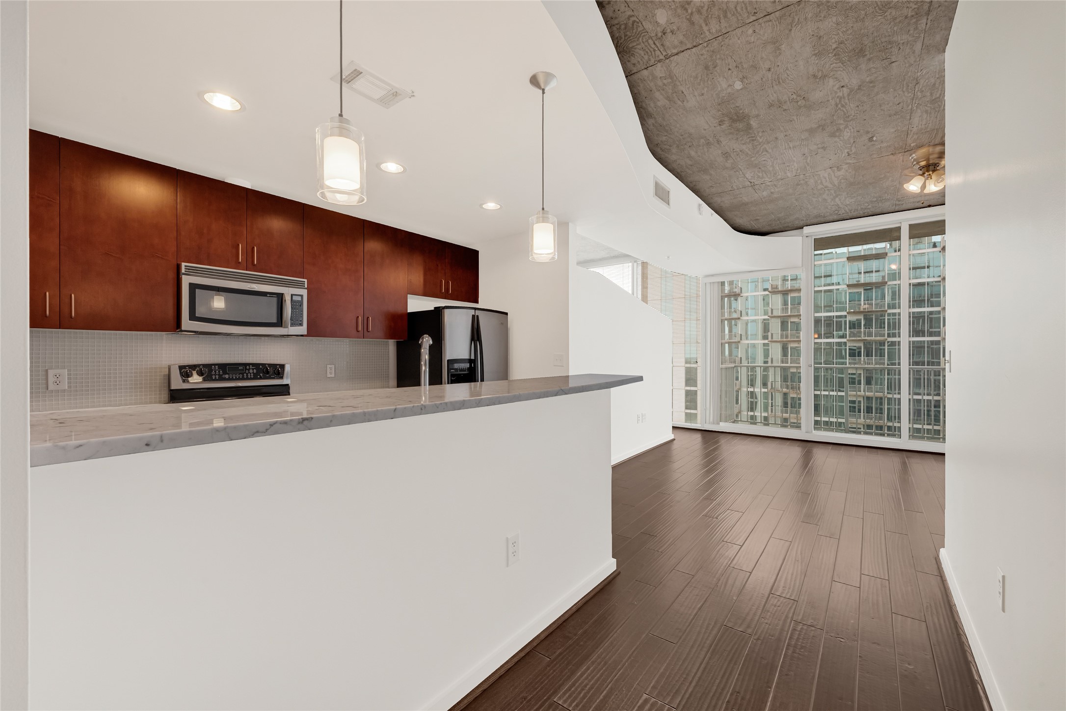 5925 Almeda Road, Unit 12308 Houston, TX 77004 - Photo 4 of 48 a kitchen with stainless steel appliances a refrigerator a sink a stove a microwave and wooden floor