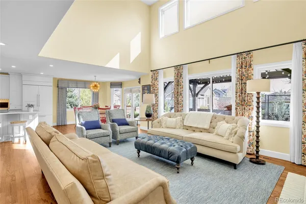 a dining room with stainless steel appliances kitchen island granite countertop a dining table chairs and a living room view