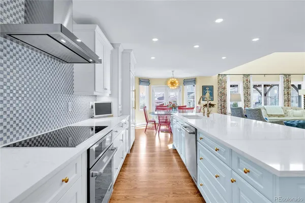 a large kitchen with stainless steel appliances lots of counter space and wooden floor