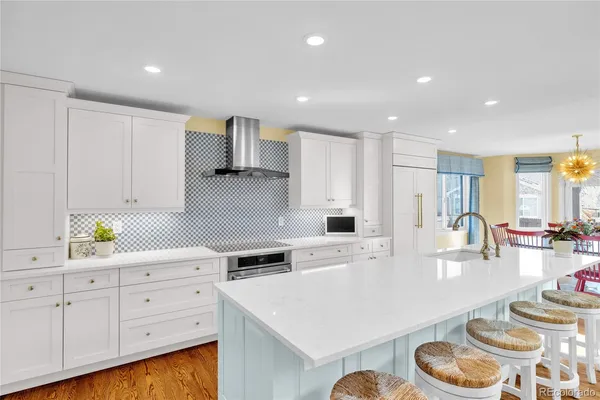a kitchen with white cabinets and sink
