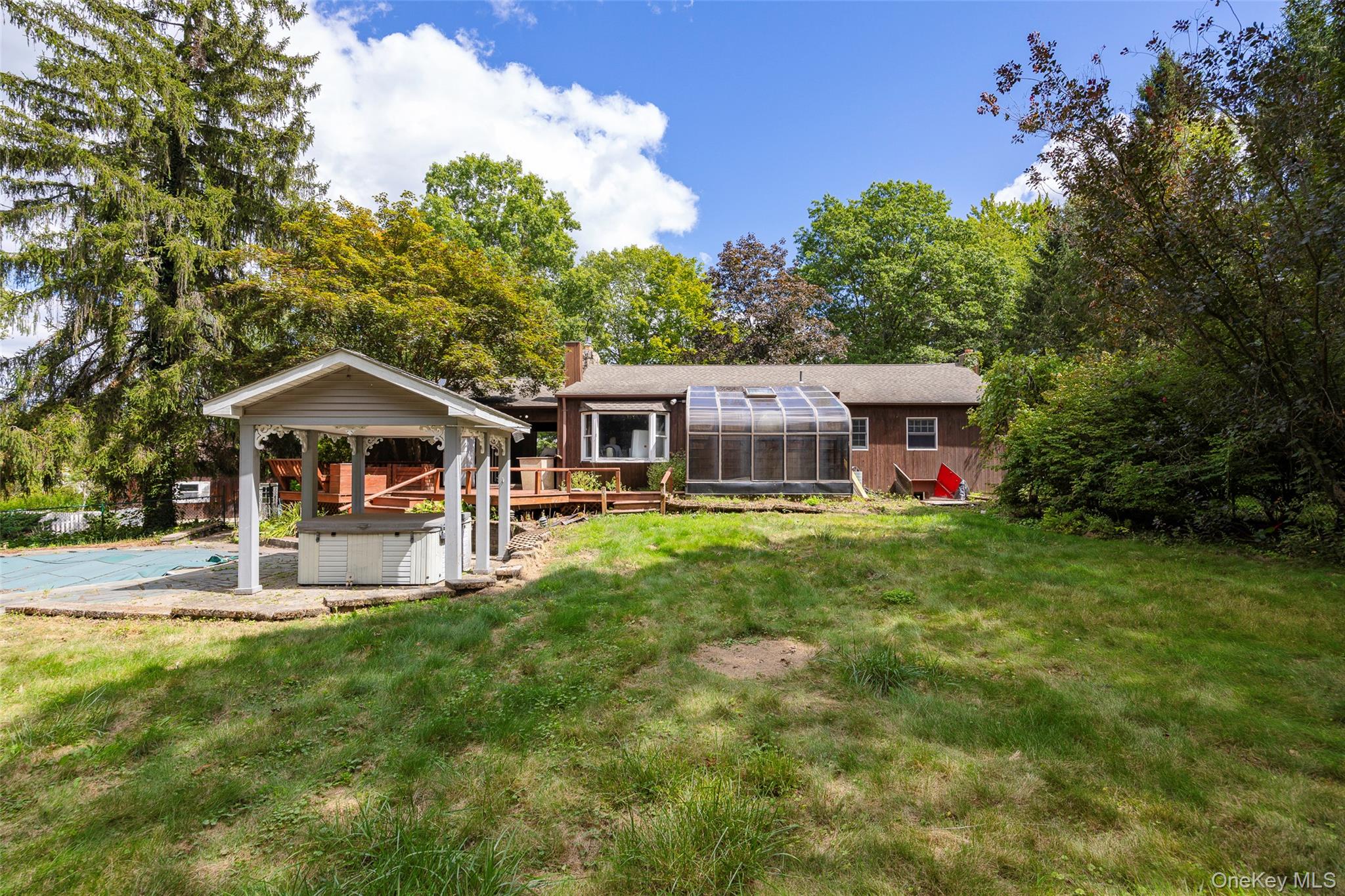 993 Highway 32 Wallkill, NY 12589 - Photo 17 of 35 Back of house with a chimney, a lawn, a wooden deck, and a hot tub