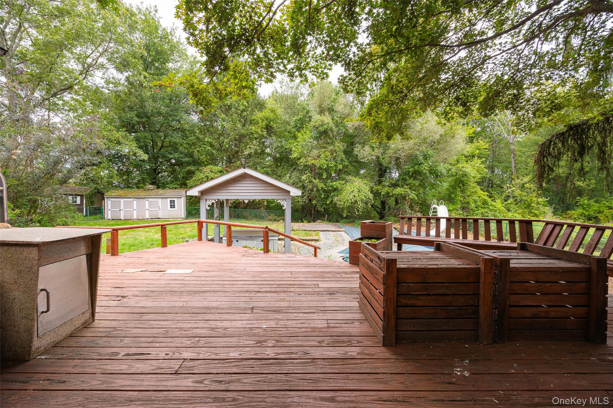 993 Highway 32 Wallkill, NY 12589 - Photo 25 of 35 Deck with a storage unit and view of scattered trees