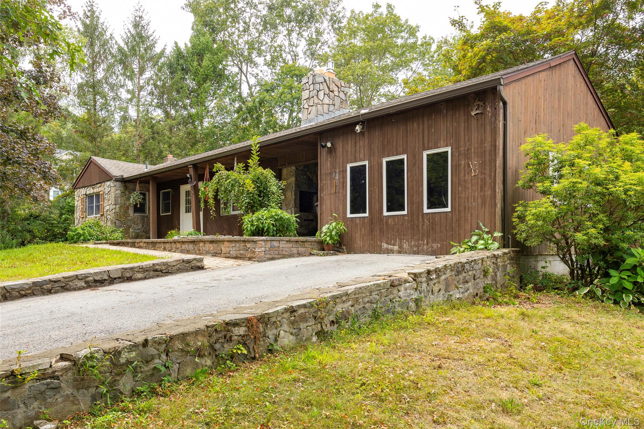 993 Highway 32 Wallkill, NY 12589 - Photo 4 of 35 View of front of property featuring a front yard, a chimney, stone siding, and view of wooded area