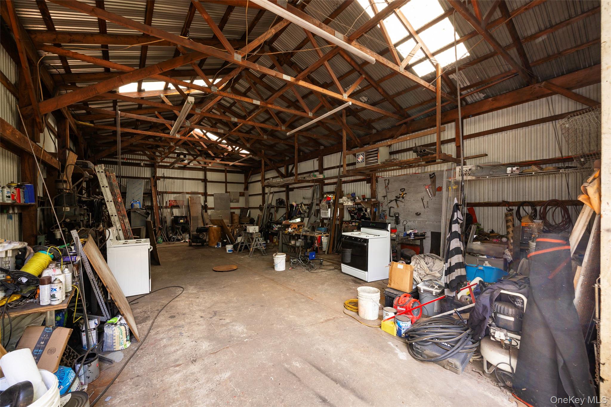 993 Highway 32 Wallkill, NY 12589 - Photo 7 of 35 Garage featuring metal wall, washer / clothes dryer, and a workshop area
