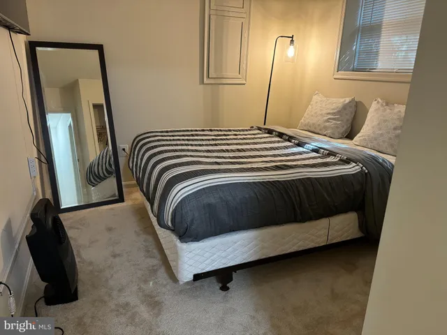 a bedroom with a bed and a mirror