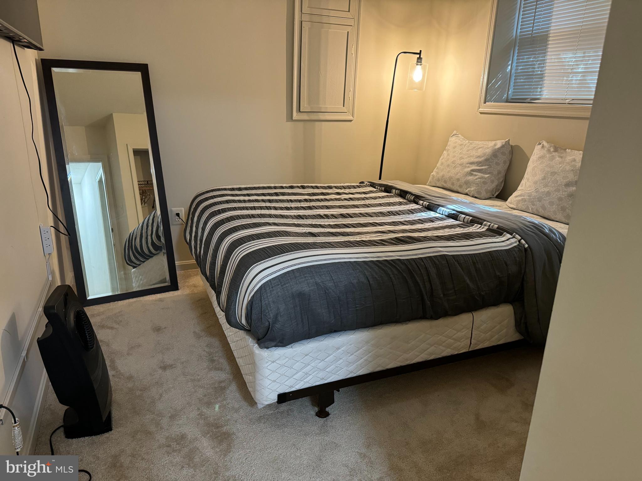 10946 Rampart Way Silver Spring, MD 20902 - Photo 8 of 11 a bedroom with a bed and a mirror