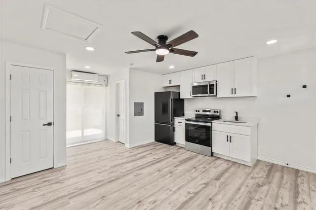 a kitchen with kitchen island a sink stainless steel appliances and cabinets