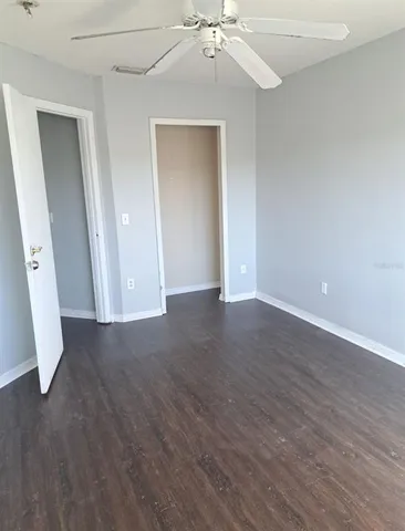 an empty room with wooden floor and carpet