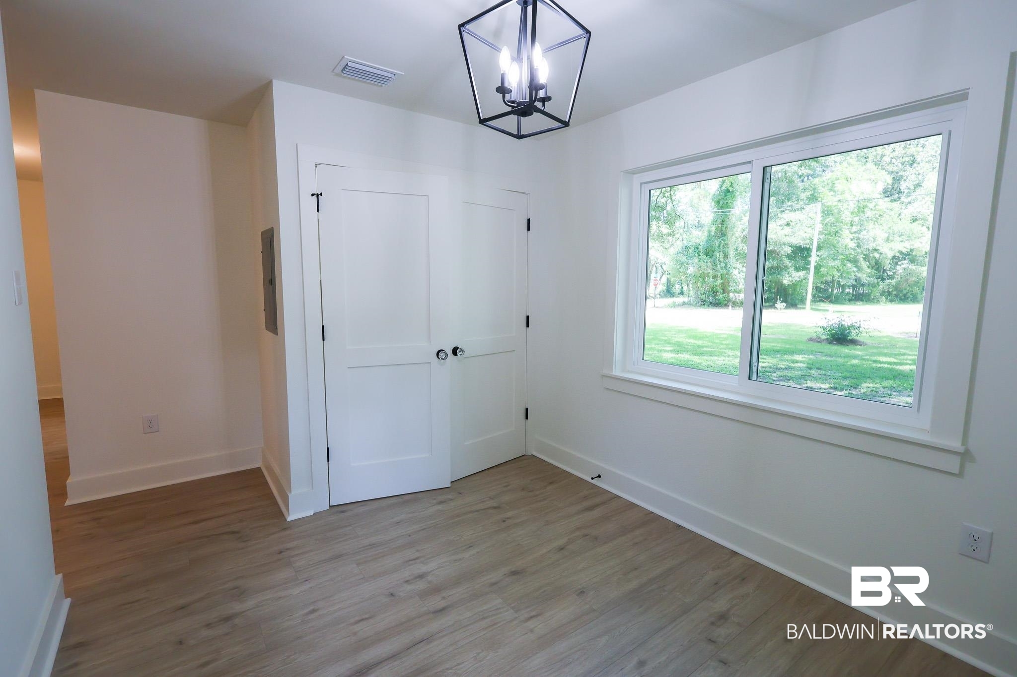 12190 Pecan Grove Street Magnolia Springs, AL 36555 - Photo 15 of 45 Empty room featuring hardwood / wood-style floors and a chandelier