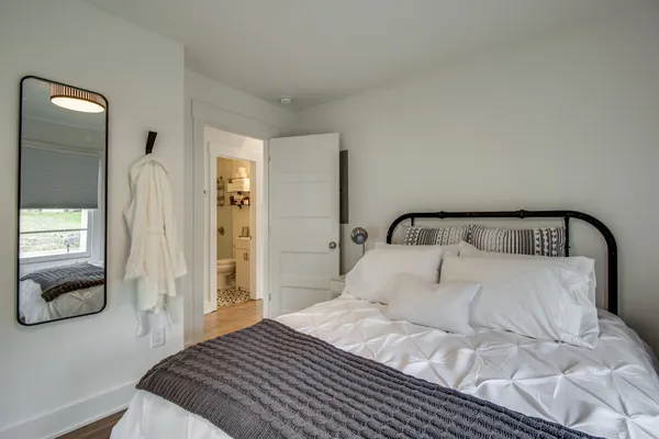 a bedroom with a bed and a mirror