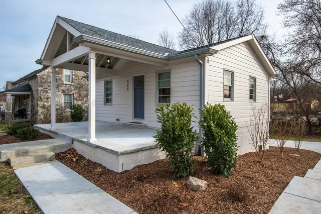 a front view of house with a yard and potted plants