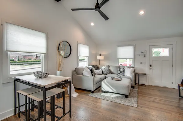 a living room with furniture a table and wooden floor