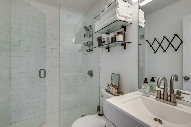 a bathroom with a sink a toilet and shower