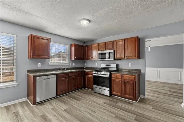 a view of a kitchen with refrigerator and wooden floor