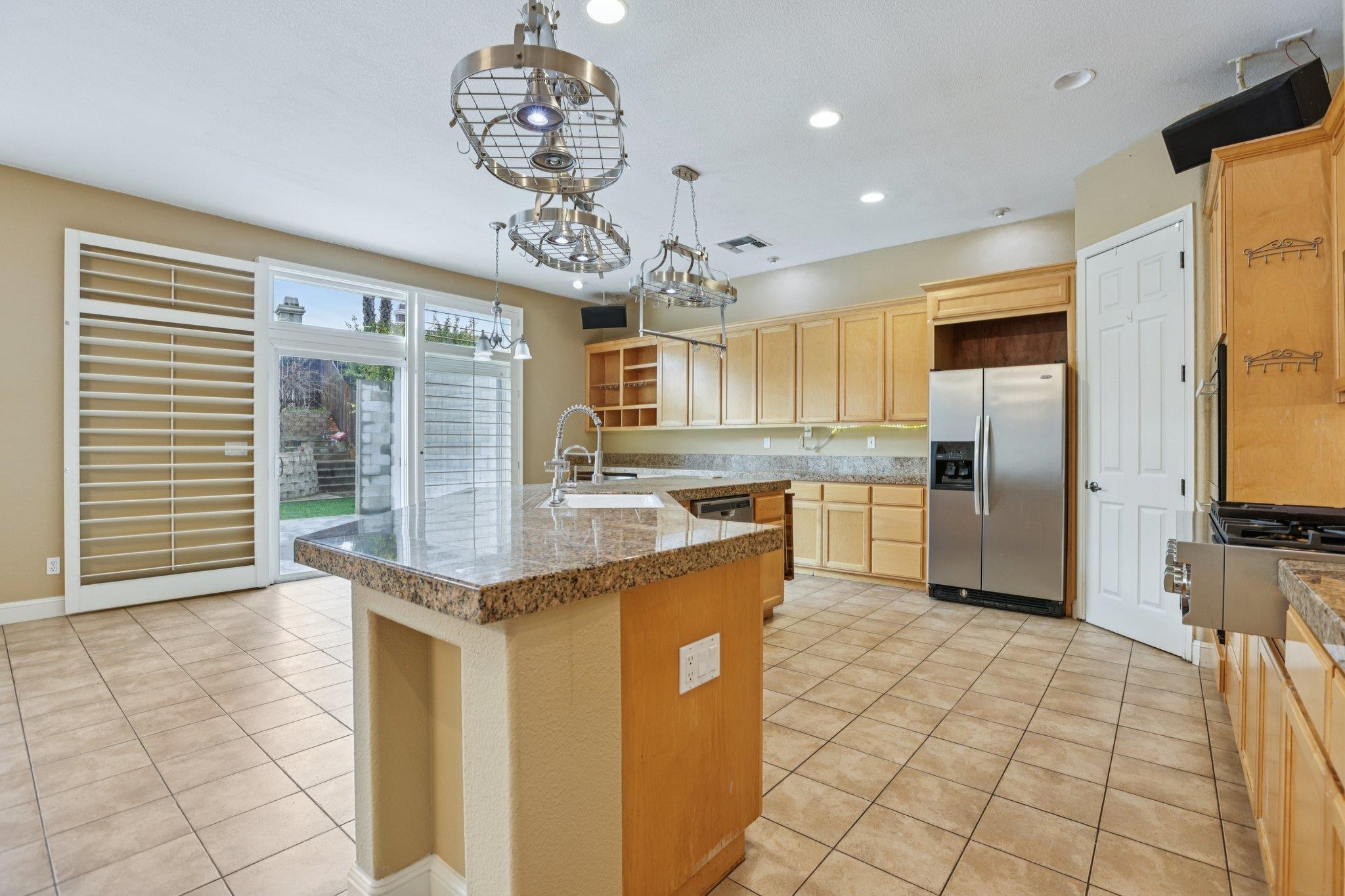 5227 Ramsdell Court Antioch, CA 94531 - Photo 11 of 58 Kitchen with open shelves, light tile patterned flooring, stainless steel appliances, pendant lighting, and light wood finish cabinetry