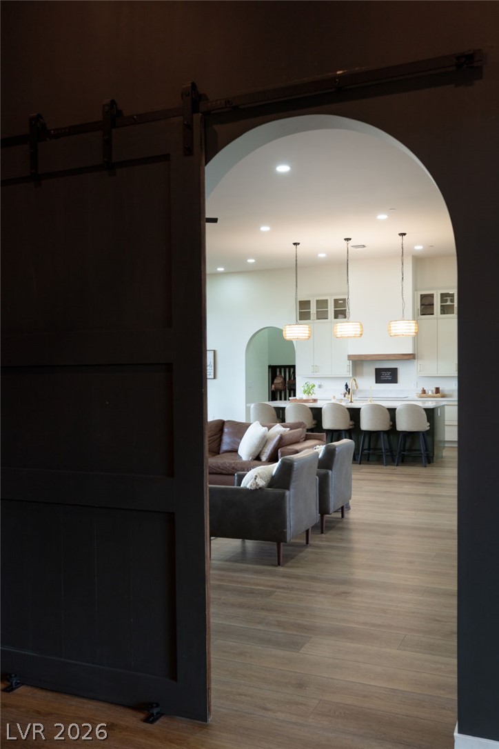 324 Wanda Road Henderson, NV 89002 - Photo 16 of 96 An arched doorway opens to reveal wood flooring and recessed lighting throughout the main level.