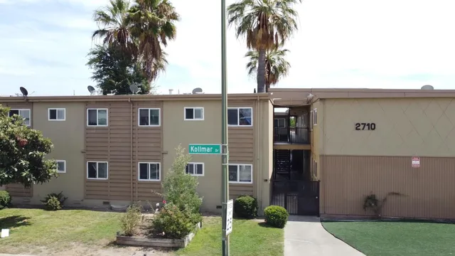 front view of house with a yard and potted plants