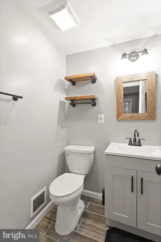 a bathroom with a toilet a sink and mirror