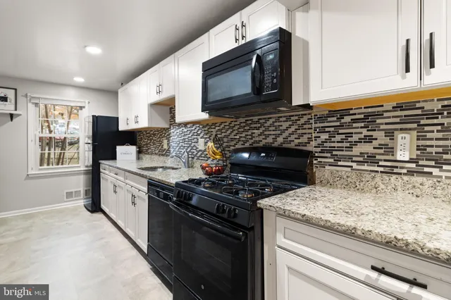 a kitchen with granite countertop stainless steel appliances a stove sink and microwave