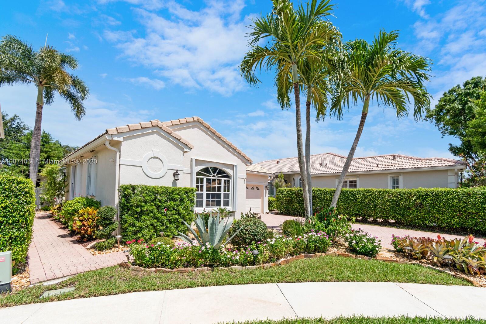 23434 Rakelle Circle Boca Raton, FL 33433 - Photo 1 of 40 a view of a white house with a yard and potted plants
