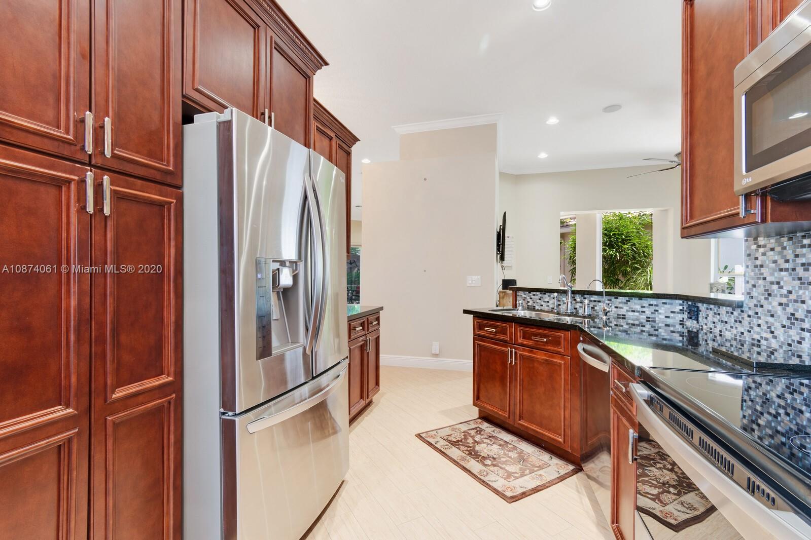 23434 Rakelle Circle Boca Raton, FL 33433 - Photo 5 of 40 a kitchen with stainless steel appliances granite countertop a refrigerator a stove and a sink