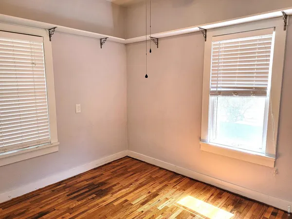 a view of a room with wooden floor and a window