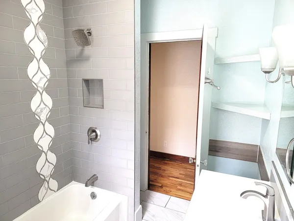 a bathroom with a tub a sink and a window