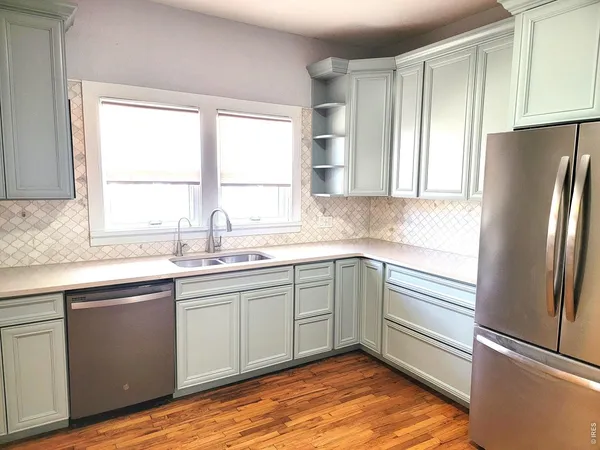 a kitchen with stainless steel appliances granite countertop a refrigerator sink and window
