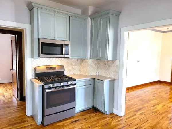 a kitchen with granite countertop cabinets stainless steel appliances and wooden floor