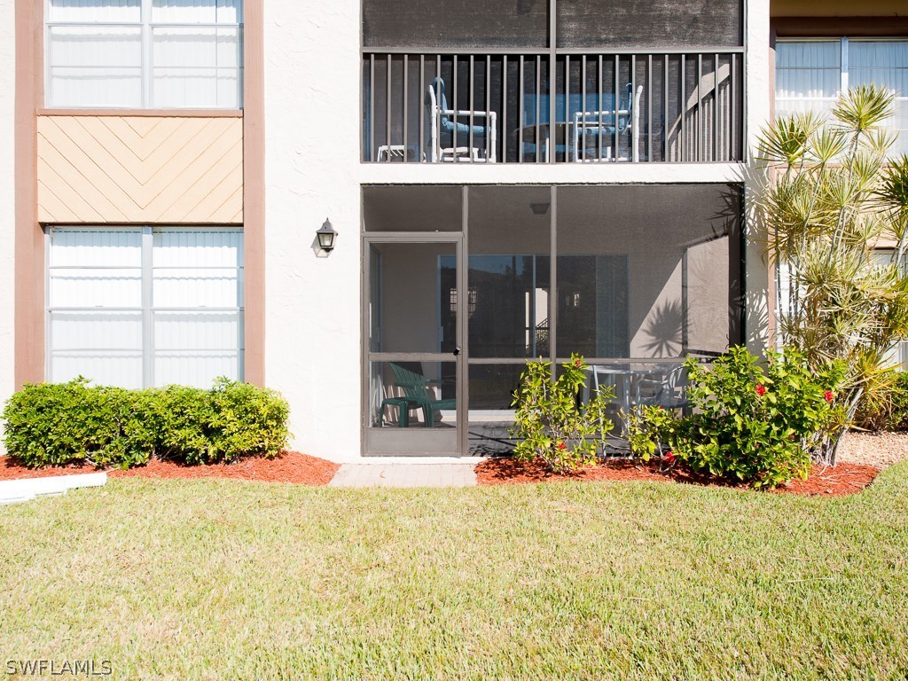 16881 Davis Road, Unit 414 Fort Myers, FL 33908 - Photo 14 of 24 a view of a house with a small yard and flower plants