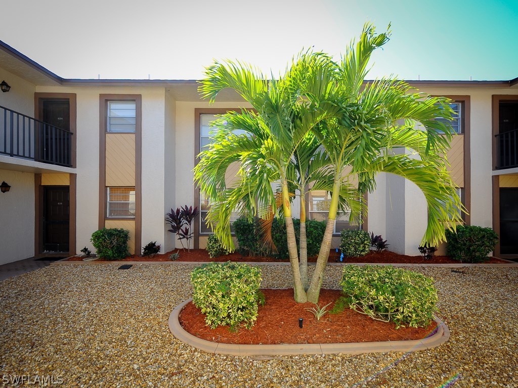 16881 Davis Road, Unit 414 Fort Myers, FL 33908 - Photo 17 of 24 a view of a house with a yard and potted plants