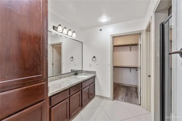 a bathroom with a granite countertop sink and a mirror