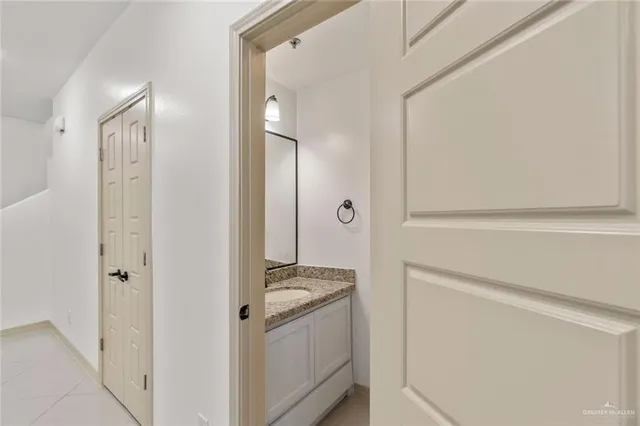 a bathroom with a granite countertop sink and a mirror