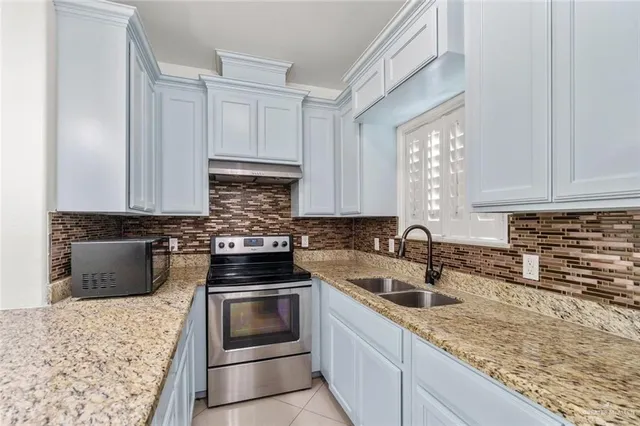 a kitchen with granite countertop a sink and a stove